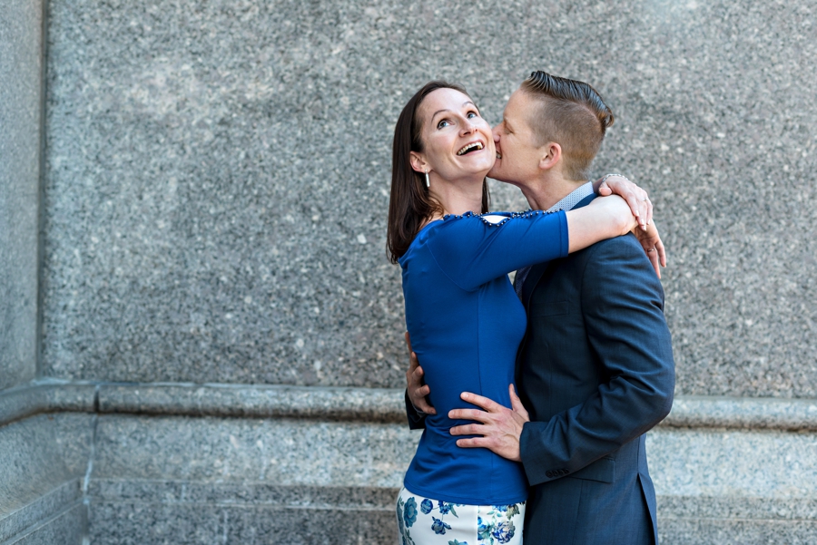 A man kissing his fiance's ear during their engagement session in philadelphia.